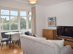 uma sala de estar com um sofá e uma mesa com cadeiras em Sea Breeze Apartment em Goring by Sea