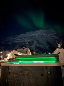 una luz verde en el techo de una casa con una montaña en Alpan Apartments, Lyngenfjord, en Olderdalen