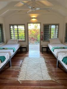 a room with three beds and a rug on the floor at Mai Sunset Island Resort in Naviti Island