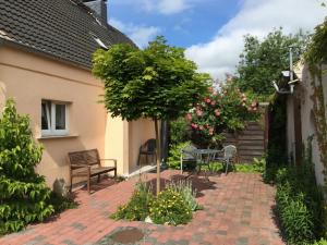 eine Terrasse mit einem Tisch, Stühlen und Blumen in der Unterkunft Ferienhaus in Bartelshagen II in Hessenburg