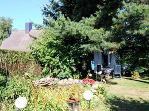 a garden with a table and chairs in front of a house at Ferienhaus mit Garten am Bodstedter Bodden in Bodstedt