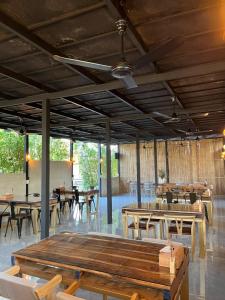 ein Restaurant mit Holztischen, Stühlen und Fenstern in der Unterkunft Isbjorn chiangdao in Chiang Dao