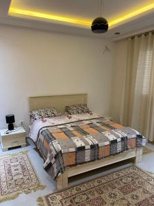 a bedroom with a bed in a room with a rug at Villa El mansoura S+3 in Kelibia