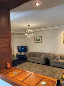 a living room with a couch and a tv at Villa El mansoura S+3 in Kelibia