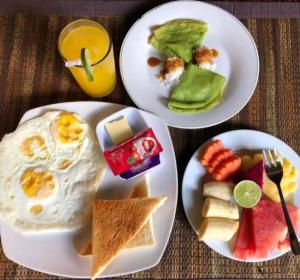 tres platos de desayuno en una mesa en Nugraha Guesthouse 1, en Ubud