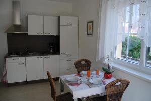 a kitchen with a white table and chairs and a table and chairsktop at Apppartement Florian - Die perfekte Verbindung zwischen Großstadt und Natur - b44113 in Vienna