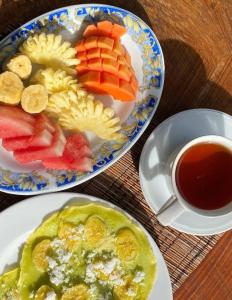 a table with two plates of food and a cup of tea at Nugraha Guesthouse 1 in Ubud