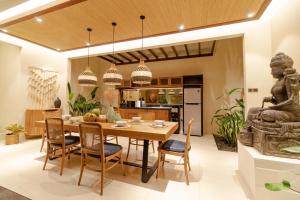 a kitchen and dining room with a table and chairs at La Rose Villas and Suites Camp Canggu in Canggu