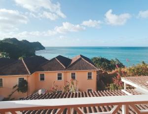 a view of the ocean from the balcony of a house at Beachfront Acqua Villa in Five Islands Village