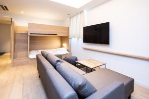 a living room with a couch and a flat screen tv at ROTA105 in Osaka
