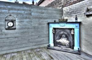 a blue fireplace with a clock on a brick wall at Kraken Cottage in Bridlington
