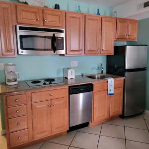 a kitchen with wooden cabinets and stainless steel appliances at Champagne Isle Resort Unit 107 in Wildwood