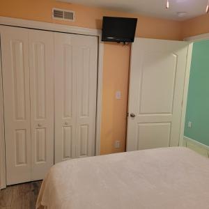 1 dormitorio con 1 cama y 2 puertas blancas en Champagne Isle Resort Unit 107, en Wildwood