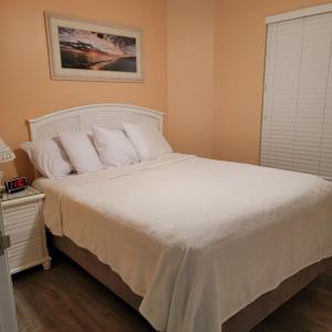 een slaapkamer met een groot bed met witte lakens en kussens bij Champagne Isle Resort Unit 107 in Wildwood