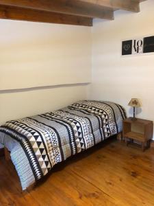 1 dormitorio con 1 cama con manta blanca y negra en Eco Boutique San Fernando en San Fernando