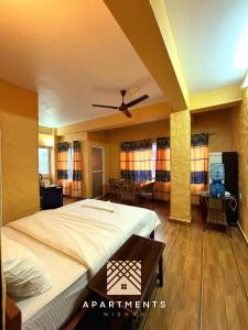 um quarto com uma cama, uma mesa e cadeiras em Nishan Apartments -Lakeside em Pokhara