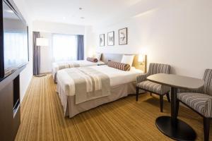 a hotel room with two beds and a table at Hotel Mystays Premier Hamamatsucho in Tokyo +35 photos