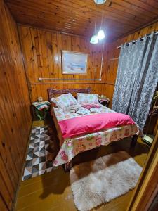 um quarto com uma cama num quarto de madeira em Espaço encantador na Lagoa- Morada colorida: lugar de gente feliz! em Xangri-lá
