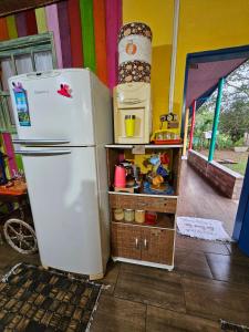 Una nevera blanca en una habitación con cocina. en Espaço encantador na Lagoa- Morada colorida: lugar de gente feliz! en Xangri-lá