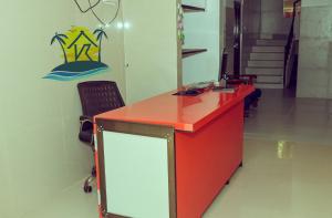 an office with a red desk and a sign on the wall at Holiday home stay in Malpe