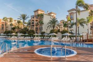 a pool at a resort with chairs and palm trees at Marriott's Marbella Beach Resort in Marbella