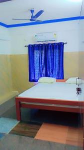 a bedroom with a bed with a blue curtain at Holiday home stay in Malpe