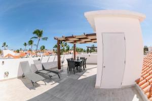 un patio avec une table et des chaises sur un toit dans l'établissement Corte Sea A302, Luxury Penthouse, à Punta Cana