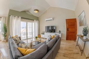 een woonkamer met een bank en een tv bij Corte Sea A302, Luxury Penthouse in Punta Cana