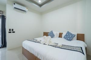 Schlafzimmer mit einem Bett mit blauen und weißen Kissen in der Unterkunft T-OneHome in Phetchabun