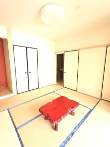 Zimmer mit einem roten Teppich auf dem Boden in der Unterkunft 知輪-chirin- in Sakai