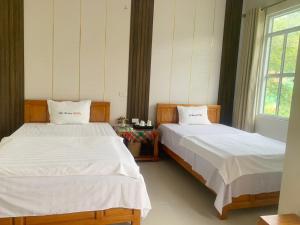 dos camas sentadas una al lado de la otra en un dormitorio en Khách sạn Việt Hoàng, en Bảo Lạc