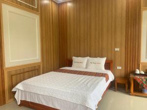 1 dormitorio con 1 cama con 2 almohadas en Khách sạn Việt Hoàng, en Bảo Lạc