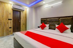 um quarto com uma cama grande e almofadas vermelhas em OYO Flagship Hotel Love Inn em Lucknow