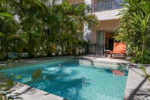 uma piscina com uma cadeira e palmeiras em Huayu Resort & Spa Yalong Bay Sanya em Sanya