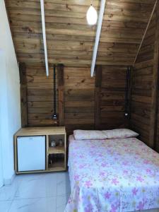 Schlafzimmer mit einem Bett und einem TV in der Unterkunft Casa - Chalé da praia in Pontal do Paraná