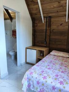 ein Schlafzimmer mit einem Bett und ein Badezimmer mit einem WC in der Unterkunft Casa - Chalé da praia in Pontal do Paraná