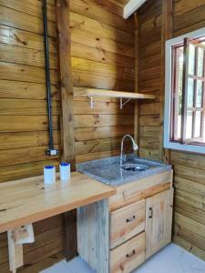 eine Küche mit einem Waschbecken in einer Holzhütte in der Unterkunft Casa - Chalé da praia in Pontal do Paraná