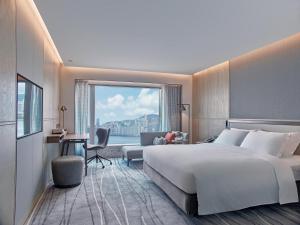 a hotel room with a large bed and a large window at New World Millennium Hong Kong Hotel in Hong Kong
