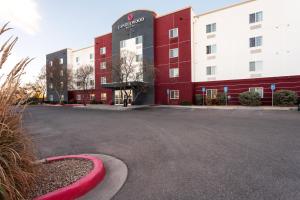 a red and white building with a parking lot at Candlewood Suites Roswell by IHG in Roswell
