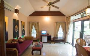 a living room with a couch and a tv at Baan Orapin in Chiang Mai