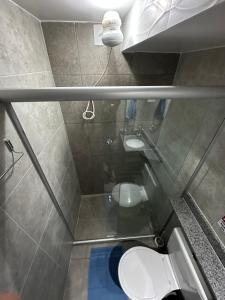 a bathroom with a toilet and a sink at Quarto privativo com banheiro compartilhado,a 800mts do pátio do forró in Caruaru