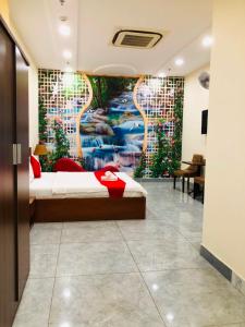 ein Schlafzimmer mit einem Bett und einem Wandgemälde in der Unterkunft Dũng India Hotel in Ho-Chi-Minh-Stadt