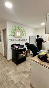 a couple of people looking into a oven in a kitchen at Hostal Villa Marta in Santa Ana