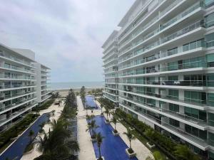 - un grand bâtiment à côté d'une plage bordée de palmiers dans l'établissement Cartagena, à Carthagène des Indes