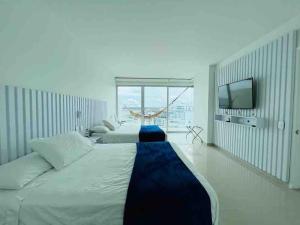 um quarto com 2 camas e uma televisão de ecrã plano em Cartagena em Cartagena das Índias