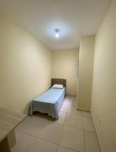 um pequeno quarto com uma cama num quarto em Paulo Eduardo Acomodações em Boituva