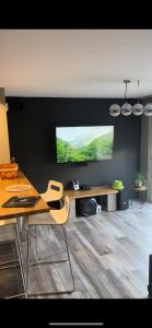 sala de estar con mesa y TV de pantalla plana en Lepadaloft en Villeneuve-Saint-Georges