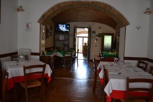 a dining room with tables and chairs and a television at Da Bianchina in Capanne