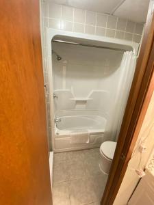 a small bathroom with a tub and a toilet at Bavarian Inn in Bruce Mines