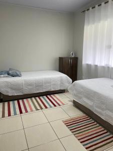 - une chambre avec 2 lits et un tapis dans l'établissement Casa com ótima localização, à Foz do Iguaçu